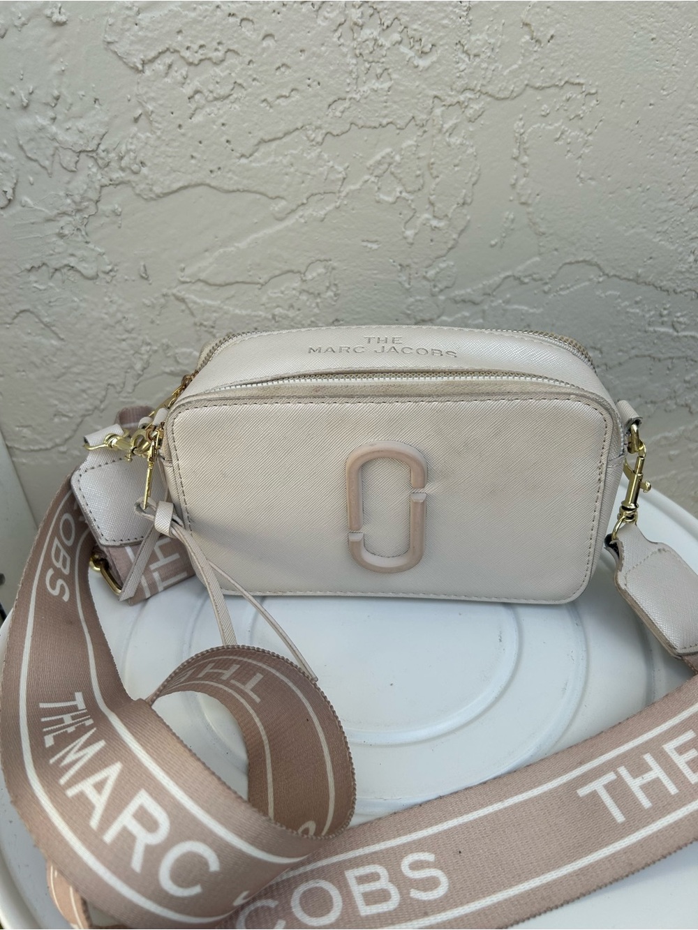 Marc Jacobs Snapshot camera bag in a white or cream Saffiano leather.